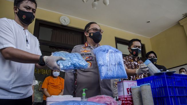 Kapolrestabes Bandung Kombes Pol Ulung Sampurna Jaya (kedua kiri) menunjukkan barang bukti sarung tangan medis bekas siap edar saat rilis pengungkapan di Polrestabes Bandung, Bandung, Jawa Barat, Jumat (20/11/2020). [ANTARA FOTO/Novrian Arbi]