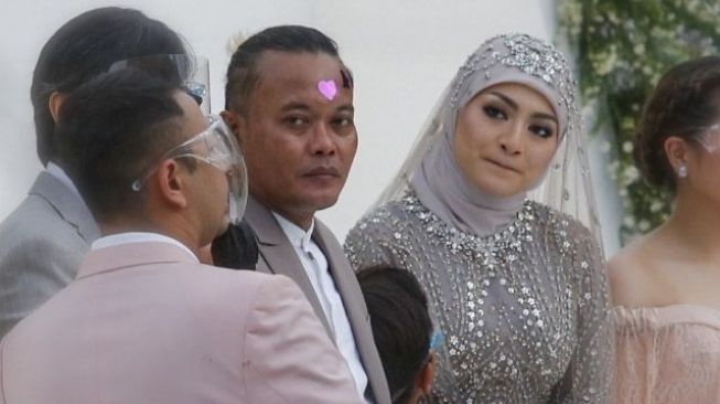 Komedian Sule saat melangsungkan akad nikah dengan Nathalie Holscher di Kawasan Jatisampurna, Bekasi, Jawa Barat, Minggu (15/11). Sule akhirnya melepas status duda yang dua tahun disandangnya setelah hari ini dia resmi menikahi Natalie Holscher.

Ayah dari Rizky Febian itu menikahi Nathalie dengan mas kawin mewah berupa uang Rp 200 juta, emas 75 gram serta seperangkat alat salat.


Pernikahan Sule dan Nathalie Holscher diadakan secara tertutup karena masih ditengah pandemi. Hanya keluarga dan rekan terdekat saja yang hadir. [Suara.com/Alfian Winanto]