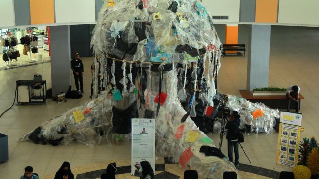 Sejumlah pengunjung melintas di dekat replika ubur-ubur yang terbuat dari sampah plastik di Mall Mamuju, Sulawesi Barat, Jumat (20/11/2020). [ANTARA FOTO/ Akbar Tado]