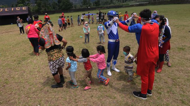 Seorang relawan menggunakan kostum super hero saat bermain bersama anak-anak di Tempat Pengungsian Sementara Gunung Merapi, Klakah, Selo, Boyolali, Jawa Tengah, Sabtu (21/11/2020).  [ANTARA FOTO/Aloysius Jarot Nugroho]
