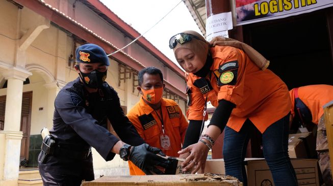 Personel detasemen Gegana bersama relawan membawa logistik saat penyaluran bantuan bagi pengungsi di tempat pengungsian Merapi Desa Deyangan, Magelang, Jateng, Sabtu (21/11/2020).  [ANTARA FOTO/Anis Efizudin]