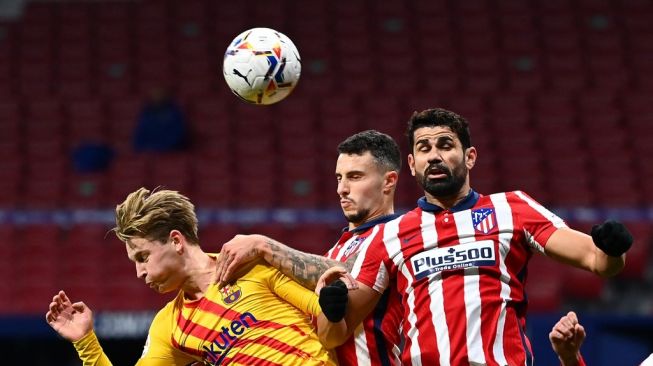 Penyerang Atletico Madrid Diego Costa (kanan) menyundul bola saat menghadapi Barcelona pada pertandingan pekan ke-10 Liga Spanyol di Estadio Wanda Metropolitano, Madrid, Minggu (22/11/2020) dini hari WIB. [GABRIEL BOUYS / AFP] 