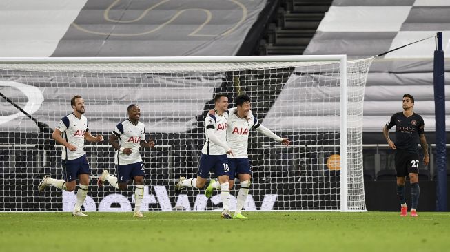 Gelandang Tottenham Hotspur Giovani Lo Celso (tengah) merayakan gol kedua timnya dengan striker Tottenham Hotspur Son Heung-Min (2R) selama pertandingan sepak bola Liga Premier Inggris antara Tottenham Hotspur melawan Manchester City di Tottenham Hotspur Stadium, London, pada (21/11/2020). [Clive Rose / POOL / AFP]