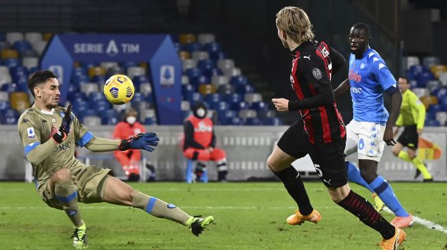 Pemain depan AC Milan Jens Petter Hauge mencetak gol ketiga timnya melewati kiper Napoli Alex Meret selama pertandingan sepak bola seri A Italia Napoli vs AC Milan di stadion San Paolo, Naples pada (22/11/2020). [ANDREAS SOLARO / AFP]