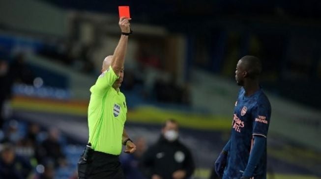 Wasit Anthony Taylor memberikan kartu merah kepada gelandang Nicolas Pepe (kanan) saat laga Liga Inggris di  Elland Road. MOLLY DARLINGTON / POOL / AFP