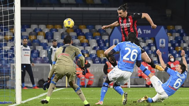 Penyerang AC Milan Zlatan Ibrahimovic mencetak gol keduanya melewati penjaga gawang Napoli Alex Meret (kiri) selama pertandingan sepak bola Serie A Italia Napoli vs AC Milan di stadion San Paolo, Naples pada (22/11/2020). [ANDREAS SOLARO / AFP]