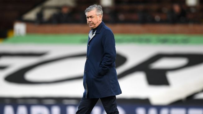 Pelatih Everton, Carlo Ancelotti berjalan di lapangan sebelum laga Liga Inggris 2020/2021 kontra Fulham di Craven Cottage, London, Minggu (22/11/2020) malam WIB. [DANIEL LEAL-OLIVAS / POOL / AFP]