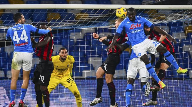 Bek Napoli Kalidou Koulibaly (kanan) dan bek AC Milan Simon Kjaer melakukan sundulan disaksikan penjaga gawang AC Milan Antonio Donnarumma selama pertandingan sepak bola seri A Italia Napoli vs AC Milan di stadion San Paolo, Naples pada (22/11/2020). [ANDREAS SOLARO / AFP]