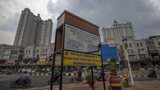 Papan informasi jumlah kasus COVID-19 Kecamatan Tanjung Priok dengan instalasi replika peti mati terpasang di kawasan Danau Sunter, Jakarta, Senin (23/11/2020). [ANTARA FOTO/Aditya Pradana Putra]