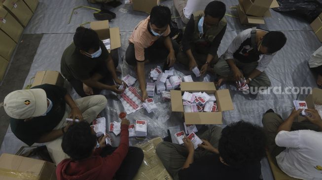 Petugas menyortir surat suara Pilkada Depok di gudang logistik Komisi Pemilihan Umum (KPU) Kota Depok, Cimanggis, Depok, Jawa Barat, Selasa (24/11/2020). [Suara.com/Angga Budhiyanto]