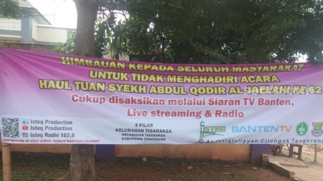 Pemkab Tangerang memasang spanduk imbauan warga tak hadiri haul Syekh Abdul Qodir Jaelani di Ponpes Al-Istiqlaliyyah, Selasa (24/11/2020). [Suara.com/Ridsha Vimanda Nasution]