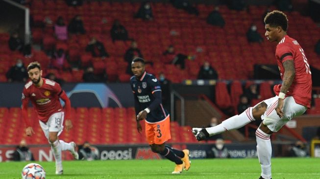 Penyerang Manchester United Marcus Rashford mencetak gol lewat penalti saat menghadapi Istanbul Basaksehir di matchday keempat Grup H Liga Champions, di Old Trafford, Manchester, Rabu (25/11/2020) dini hari WIB. [Oli SCARFF / AFP]