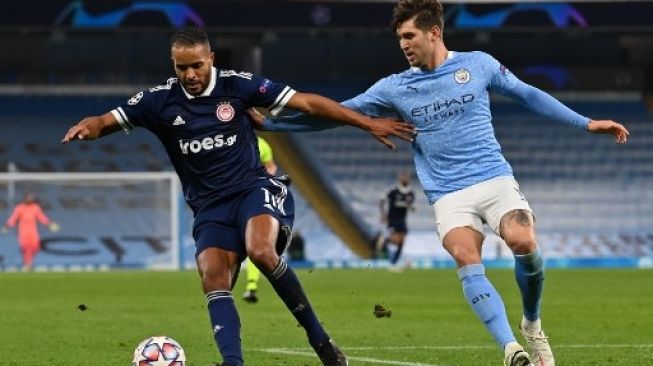 Striker Olympiakos Youssef El-Arabi (kiri) ditempel ketat oleh bek Manchester City John Stones saat laga Liga Champions di Etihad Stadium, Manchester. Paul ELLIS / AFP