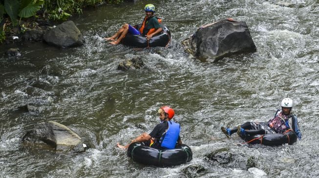 Pengunjung menikmati derasnya aliran Sungai Cikalang menggunakan river tubing di Purbaratu, Kota Tasikmalaya, Jawa Barat, Rabu (25/11/2020). [ANTARA FOTO/Adeng Bustomi]