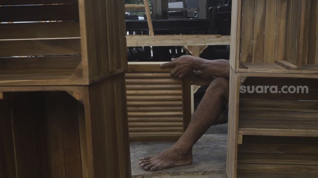 Pekerja menyelesaikan produksi mebel kayu di salah satu workshop furniture di kawasan Kemang, Jakarta, Kamis (26/11/2020). [Suara.com/Angga Budhiyanto]