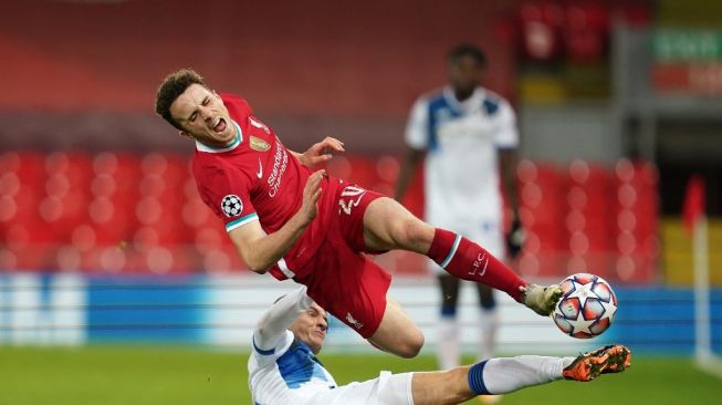 Gelandang Atalanta Marten de Roon menekel penyerang Liverpool Diogo Jota dalam laga matchday keempat Liga Champions di Stadion Anfield, Kamis (26/11/2020) dini hari WIB. [Jon Super / POOL / AFP]