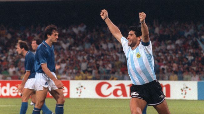 (FILES) Dalam foto file ini diambil pada 3 Juli 1990, penyerang Argentina Diego Maradona (kanan) melakukan selebrasi setelah rekan setimnya Claudio Caniggia (tidak digambarkan) menyamakan skor menjadi 1 selama pertandingan sepak bola semifinal Piala Dunia antara Italia dan Argentina di Napoli. Legenda sepak bola Argentina Diego Maradona meninggal pada 25 November 2020.DANIEL GARCIA / AFP