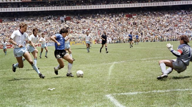 (FILES) Dalam foto file ini diambil pada tanggal 22 Juni 1986 Penyerang Argentina Diego Armando Maradona (ke-3 dari kiri) berlari melewati bek Inggris Terry Butcher (kiri) dalam perjalanannya untuk menggiring kiper Peter Shilton (kanan) dan mencetak gol keduanya, atau golnya. abad ini, selama pertandingan sepak bola perempat final Piala Dunia antara Argentina dan Inggris pada tahun 1986 di Mexico City. Legenda sepak bola Argentina Diego Maradona meninggal pada 25 November 2020. [AFP]