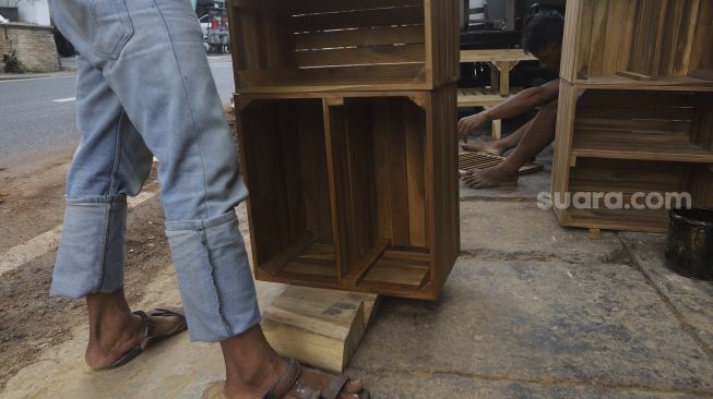 Pekerja menyelesaikan produksi mebel kayu di salah satu workshop furniture di kawasan Kemang, Jakarta, Kamis (26/11/2020). [Suara.com/Angga Budhiyanto]