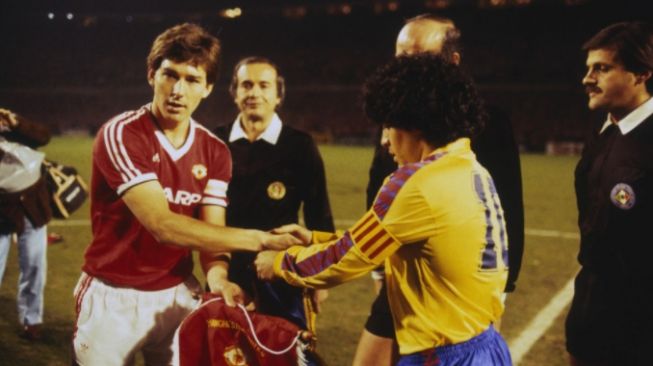 Bryan Robson, kapten Manchester United (kiri) berjabat tangan dengan kapten Barcelona, Diego Maradona sebelum laga perempatfinal Piala Winners di Old Trafford, 21 Maret 1984. [manutd.com]