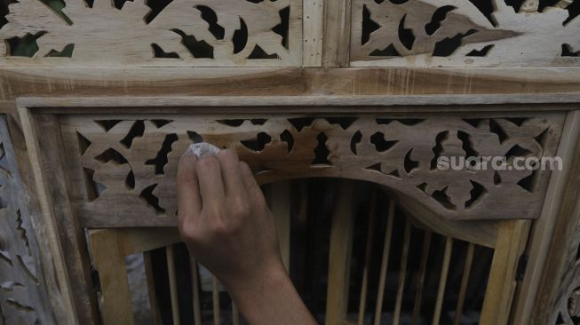 Pekerja menyelesaikan produksi mebel kayu di salah satu workshop furniture di kawasan Kemang, Jakarta, Kamis (26/11/2020). [Suara.com/Angga Budhiyanto]