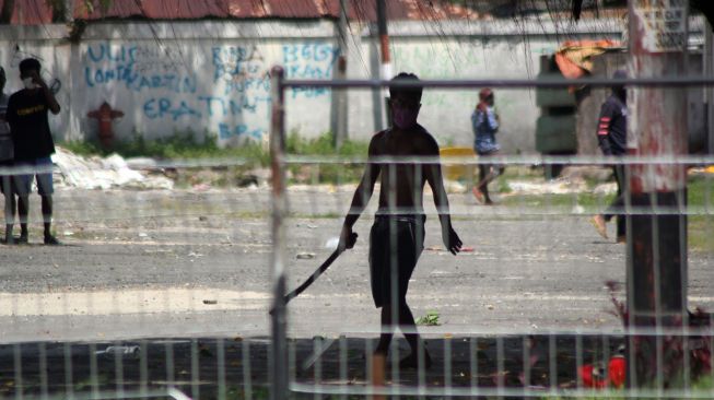 Pengunjuk rasa menenteng senjata tajam saat unjuk rasa di Kota Sorong, Papua Barat, Jumat (27/11/2020). [ANTARA FOTO/Olha Mulalind]