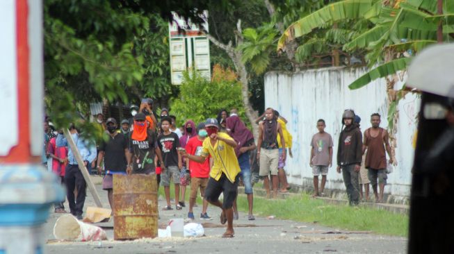 Massa melempari anggota kepolisian saat aksi unjuk rasa di Kota Sorong, Papua Barat, Jumat (27/11/2020). [ANTARA FOTO/Olha Mulalind]