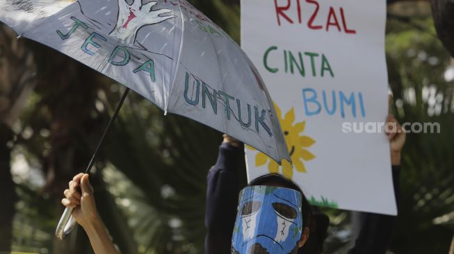 Peserta aksi Asia Climate Rally menggelar aksi unjuk rasa di depan Balai Kota Jakarta, Jumat (27/11/2020). [Suara.com/Angga Budhiyanto]