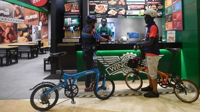 Pesepeda membeli makanan sambil membawa sepedanya di Mal Kuningan City, Jakarta Selatan, Sabtu (28/11/2020). [ANTARA FOTO/Sigid Kurniawan]