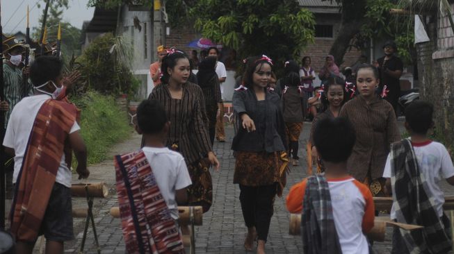 Sejumlah peserta menari dan menabuh kentongan saat tradisi wiwitan padi di Kayuhan, Sidowayah, Polanharjo, Klaten, Jawa Tengah, Sabtu (28/11/2020). [ANTARA FOTO/Aloysius Jarot Nugroho]