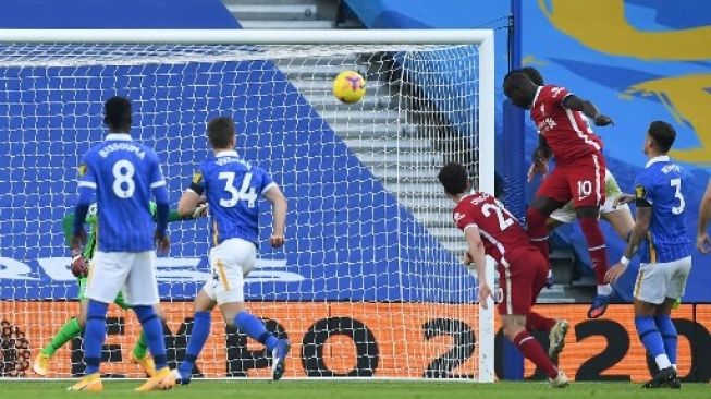 Pemain Liverpool Sadio Mane menanduk bola ke gawang Brighton dalam pertandingan Liga Premier Inggris di Amex Stadium, Sabtu (28/11/2020). [AFP]