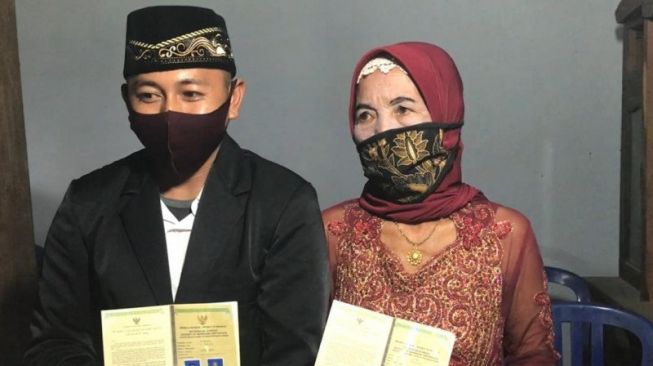 Ali, pemuda 29 tahun, dan istrinya, Yainem yang berusia 76 tahun usai menjalani prosesi pernikahan di Ponorogo, Jawa Timur pada Sabtu (28/11/2020). [Antara]