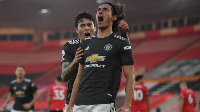 Penyerang Manchester United, Edinson Cavani (kanan) meluapkan emosinya setelah membobol gawang Southampton pada laga Liga Inggris 2020/2021 di St. Mary's Stadium, Minggu (29/11/2020) malam WIB. [MIKE HEWITT / POOL / AFP]