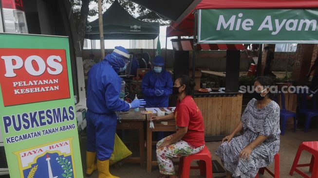 Petugas medis memeriksa kesehatan warga yang menjadi korban kebakaran di Petamburan, Jakarta, Senin (30/11/2020). [Suara.com/Angga Budhiyanto]