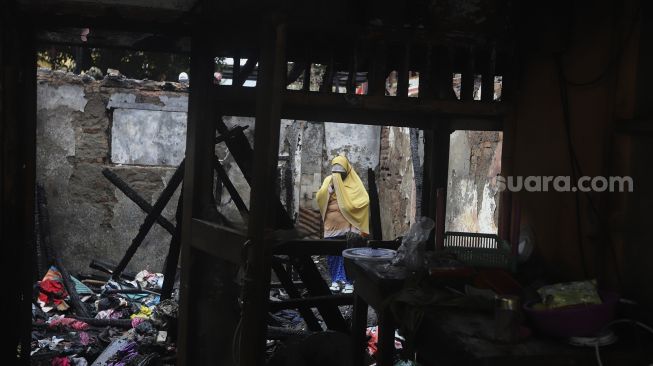 Warga mencari sisa-sisa harta benda di salah satu rumah yang terbakar di Petamburan, Jakarta, Senin (30/11/2020). [Suara.com/Angga Budhiyanto]