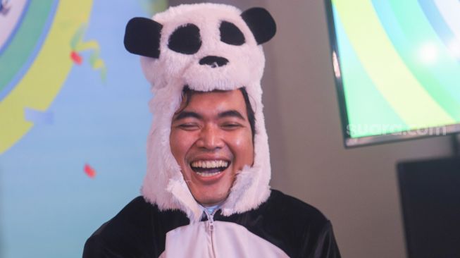 Tawa girang drummer band Wali, Tomi ketika mengenakan kostum panda dalam rangka perilisan single terbaru mereka yang berjudul 'Ondeskrayyy Ngaji (Ciluk Baa)' dan rekor Multi Platinum penjualan CD album Wali 20.20 di Jakarta Barat, Senin (30/11). [Suara.com/Alfian Winanto]