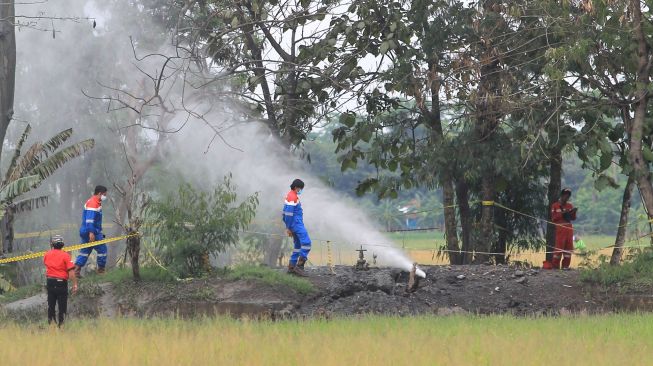 Pekerja Pertamina EP memeriksa semburan gas liar di desa Sukaperna, Tukdana, Indramayu, Jawa Barat, Senin (30/11/2020). ANTARA FOTO/Dedhez Anggara