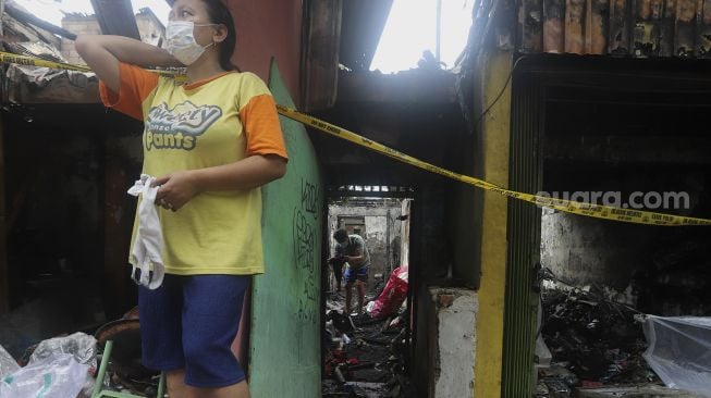 Warga mencari sisa-sisa harta benda di salah satu rumah yang terbakar di Petamburan, Jakarta, Senin (30/11/2020). [Suara.com/Angga Budhiyanto]