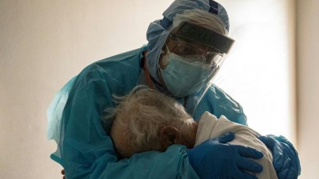 Dokter Varon peluk kakek yang outu asa karena Covid-19. (AFP)