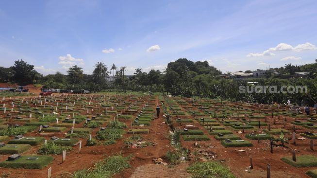 Petugas melintasi area pemakaman khusus COVID-19 di TPU Pondok Ranggon, Jakarta, Rabu (2/12/2020). [Suara.com/Angga Budhiyanto]