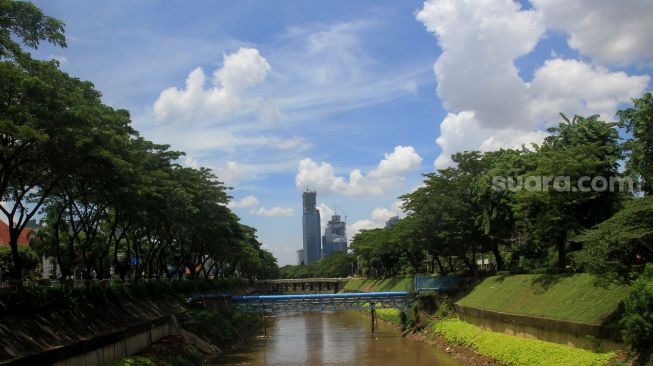 Suasana sungai ciliwung yang berlatar belakang awan biru di Jakarta, Rabu (2/12).[Suara.com/Oke Atmaja]
