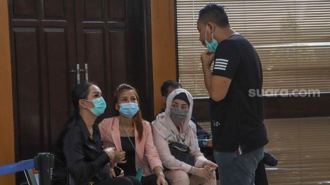 Kalina Oktarani bersama Vicky Prasetyo dan keluarganya saat menunggu dimulainya sidang lanjutan kasus pencemaran nama baik dengan mantan Istri Vicky, Angel Lelga di Pengadilan Negeri Jakarta Selatan, Rabu (2/12). [Suara.com/Alfian Winanto]