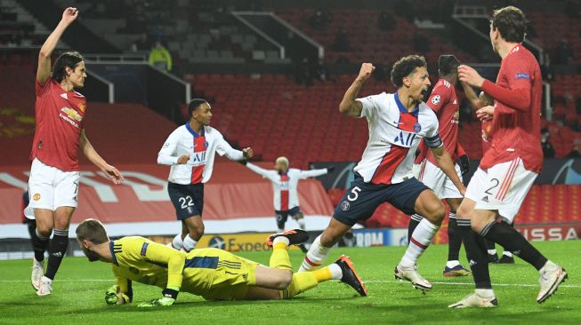 Bek Paris Saint-Germain asal Brasil Marquinhos (2R) merayakan golnya usai mencetak gol kedua timnya selama selama pertandingan sepak bola grup H Liga Champions antara Manchester United melawan Paris Saint Germain di Stadion Old Trafford, Manchester, Inggris, Kamis (3/12) dini hari WIB. 
[Oli SCARFF / AFP]
