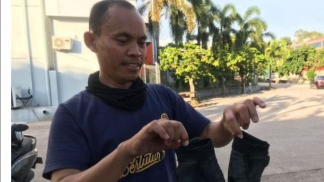 Ahmad Yudi, marbot masjid di Perumahan Eden Park memperlihatkan sarung tangan pelaku pecah kaca yang tertinggal di tempat kejadian. [Yude/Batamnews].