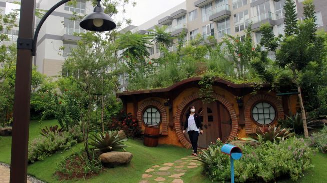 Warga berjalan di taman tematik bernuansa rumah hobbit di kawasan hunian vertikal Gading Serpong, Tangerang, Banten, Kamis (3/12/2020).  [ANTARA FOTO/Muhammad Iqbal]