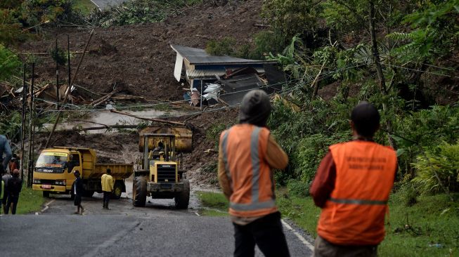 Petugas menggunakan alat berat untuk membersihkan material lumpur akibat tanah longsor di Desa Sukamulya, Talegong, Kabupaten Garut, Jawa Barat, Kamis (3/12/2020). [ANTARA FOTO/Candra Yanuarsyah]
