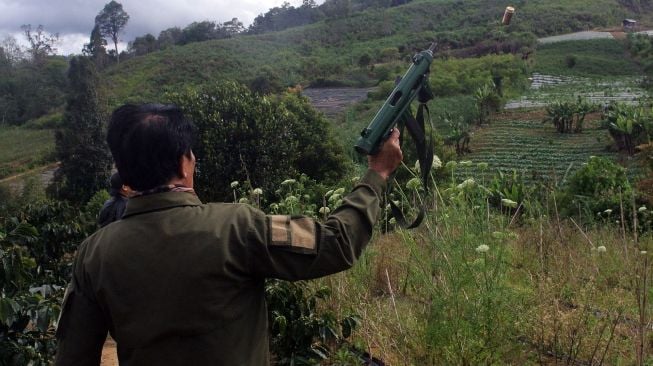 Petugas menembakkan senapan untuk mengusir harimau sumatera (panthera tigris sumatrae) di Nagari Simpang Tanjung Nan Ampek, Kecamatan Danau Kembar, Kabupaten Solok, Sumatera Barat, Kamis (3/12/2020).  [ANTARA FOTO/Iggoy el Fitra]