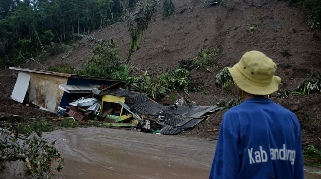 Petugas mengamati rumah yang rusak akibat tanah longsor di Desa Sukamulya, Talegong, Kabupaten Garut, Jawa Barat, Kamis (3/12/2020). [ANTARA FOTO/Candra Yanuarsyah]
