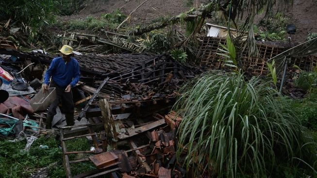 Petugas berdiri di atas puing-piung rumah akibat tanah longsor di Desa Sukamulya, Talegong, Kabupaten Garut, Jawa Barat, Kamis (3/12/2020). [ANTARA FOTO/Candra Yanuarsyah]
