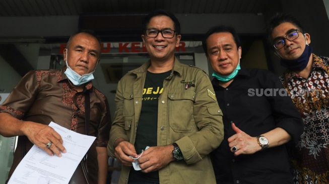 Aktor Krisna Mukti (tengah) usai membuat laporan terkait penyebaran foto dan video pribadi miliknya tanpa izin di Polda Metro Jaya, Jakarta Selatan, Jumat (4/12). [Suara.com /Alfian Winanto]